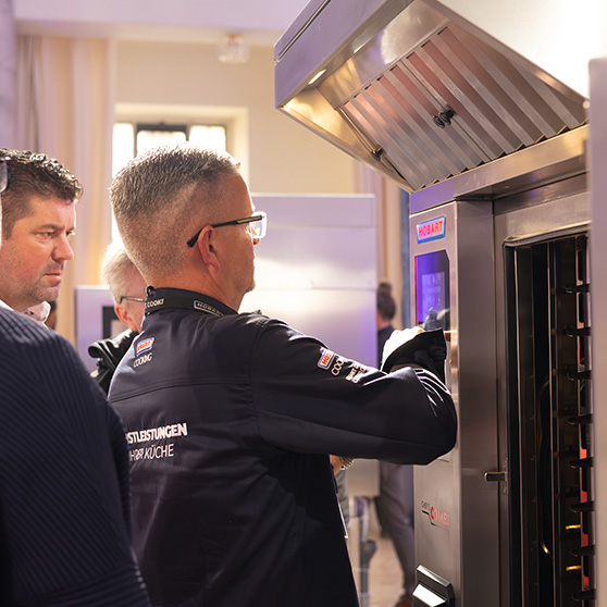 Professionelle Küchenszene mit HOBART Gerät – Person bedient das Gerät über einen modernen Touchscreen