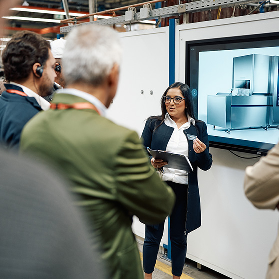 Technische Präsentation eines HOBART Geräts vor einer Gruppe in industrieller Umgebung mit Bildschirm und Tablet