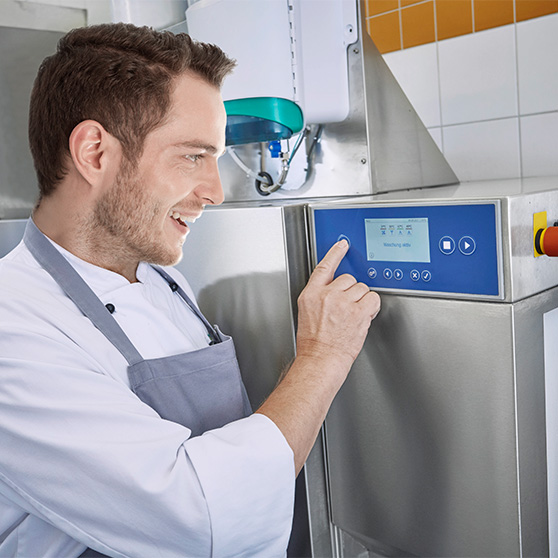 ein Mann steuert die Spülmaschine in der Küche 