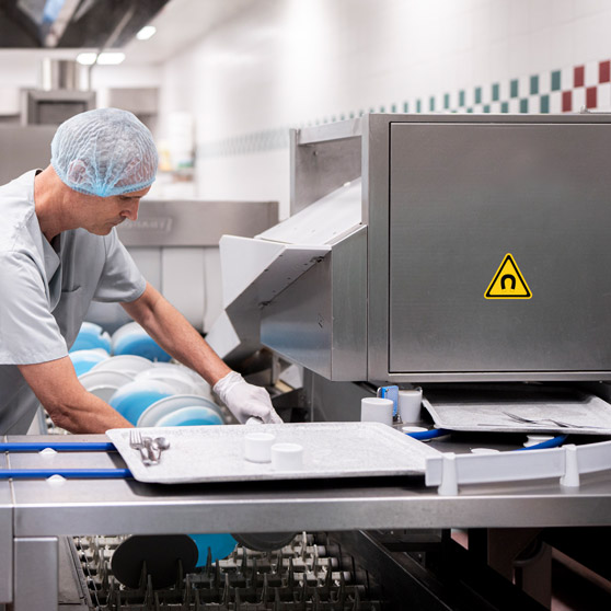 Professionelle Bandspülmaschine mit automatischem Besteckabhebemagnet und Tabletttransport, Edelstahlkonstruktion für effiziente Reinigung in Großküchen.