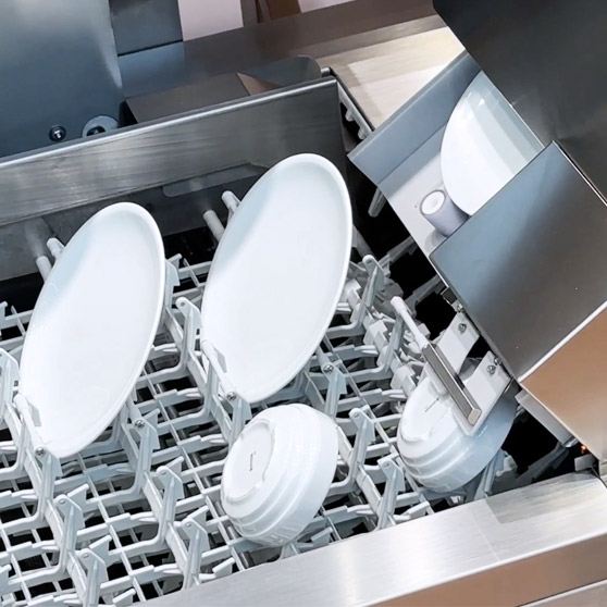 Nahaufnahme des HOBART SMART LOAD Systems mit automatischem Einlegen von Tellern und Schalen in die Halterungen der professionellen Spülmaschine für effiziente und hygienische Reinigung.
