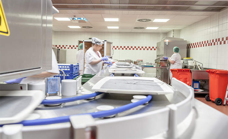 Moderne Spülküche mit HOBART FLOW Line autoLINE, automatisches Spülsystem mit Förderband und Arbeitsstationen für effiziente Reinigung von Tabletts, Tellern und Gläsern, Edelstahlkonstruktion für hygienische und optimierte Abläufe.