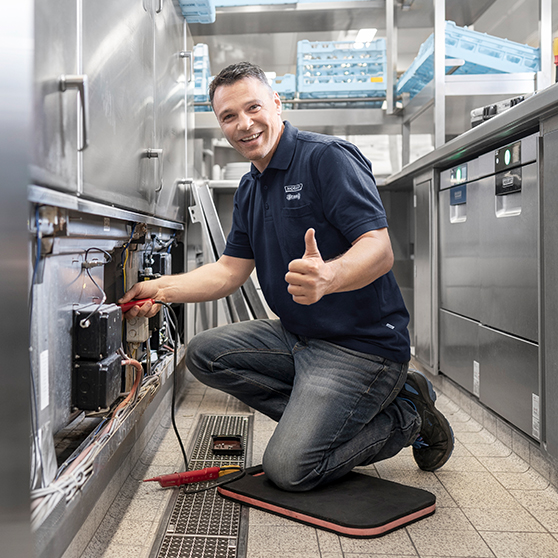 Techniker führt Wartung an geöffneter Maschine durch, Service für Gastronomiegeräte.